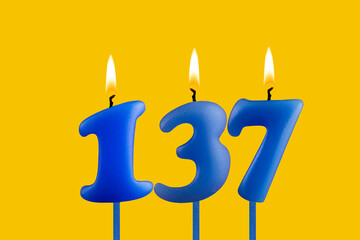 Blue candle number 137 - Birthday on yellow background