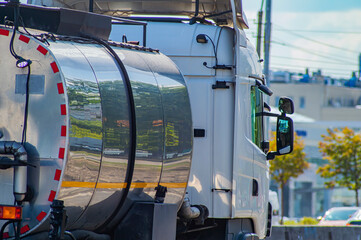 Car fuel tank on the city highway. Truck with cargo. City traffic. Transportation of fuel. Freight transportation. Asphalted road. Motor vehicles. Cargo transportation business.