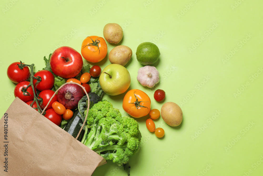 Canvas Prints Delivery of vegetarian products. Paper bag with different vegetables and fruits on green background, top view. Space for text