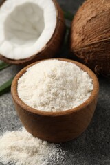 Organic coconut flour in bowl and fresh fruits on grey table, closeup