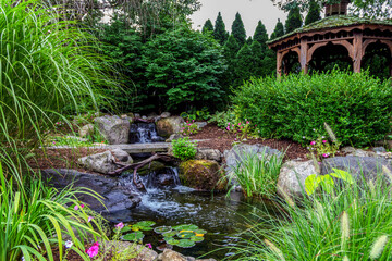 Koi pond surrounded by rocks and native flowers for backyard landscape design