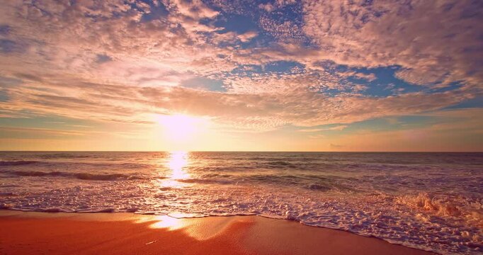 Dramatic sea sunrise or sunset sky over sea. Burning sky and shining golden waves landscape,Beautiful waves crashing on sandy shore,Amazing beach background	