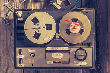 Aged reel-to-reel tape recorder and a used rolls of tape.
