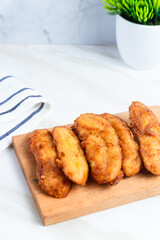 Fried Banana served on a wooden cutting board. Indonesian street food. Indonesian food. Perfect for recipe, article, catalogue, commercial, or any cooking contents.