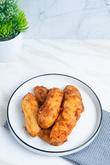 Fried Banana served on a white plate. Indonesian food. Indonesian street food. Perfect for recipe, article, catalogue, commercial, or any cooking contents.