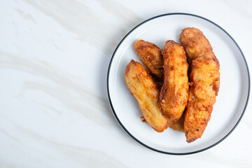 Fried Banana served on a white plate. Indonesian food. Indonesian street food. Perfect for recipe, article, catalogue, commercial, or any cooking contents.