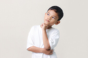 Thinking a cute little asian boy on white background. Child thinking. Education concept. Brainstorming and idea concept.