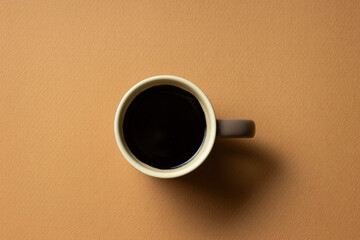 茶色の背景に置いたコーヒーカップ
