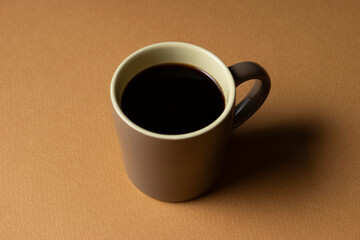 茶色の背景に置いたコーヒーカップ