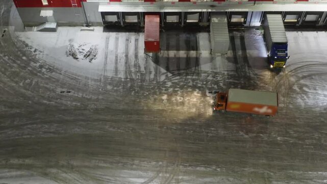 Aerial Night View: High-Tech Logistics Hub in Winter - Drone Footage of Automated Sorting Facility with Trucks and Containers | Snowy Industrial Complex