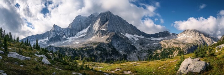 A breathtaking panorama showcasing a majestic snow-capped mountain peak rising above lush green alpine meadows under a vibrant blue sky. The scene evokes a sense of tranquility, wonder, and the vastne