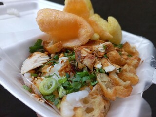 Rice chicken porridge or chicken congee from Indonesia for breakfast with a lot of  toppings fried shallot, shredded fried chicken, chip and crackers, roasted soy beans, etc. | Natural photos 