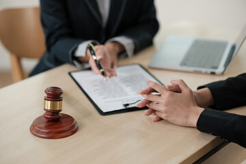 Two people are sitting at a table with a pen and a piece of paper