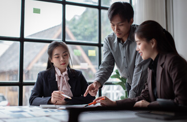 Teamwork concept. Group of asian business people working together in creative office analyze market data balance sheet account net profit to plan new sales strategies to increase production capacity.