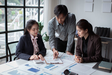 Teamwork concept. Group of asian business people working together in creative office analyze market data balance sheet account net profit to plan new sales strategies to increase production capacity.