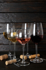 Glasses with wine and a corkscrew, on a dark background.