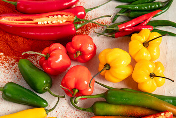 Colorful raw peppers on a light wooden background. Delicious vegetables concept.