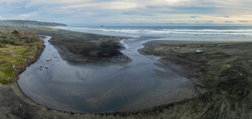 Estuary flowing into the ocean at Muriwai, Auckland, New Zealand.