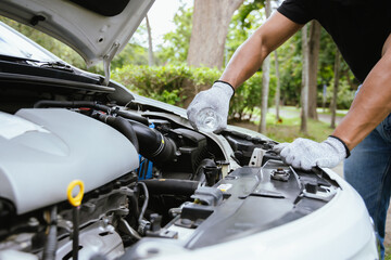 A technician in a workshop uses a wireless device to check a car's condition, updating a digital certificate. The scene highlights automotive repair, service, and efficiency in maintenance.