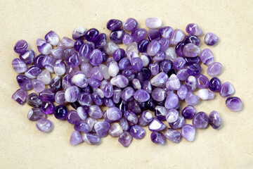 Set of various amethyst natural mineral stones and gemstones on grey fabric background partial...