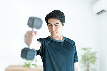 ダンベルを持ちカメラ目線の男性