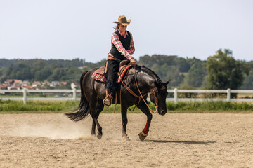 Western riding concept: A young woman and her black quarter horse stallion doing some reining dressage lessons and interacting together