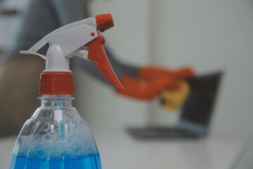 Woman cleaning table using rag and diffuser at home.