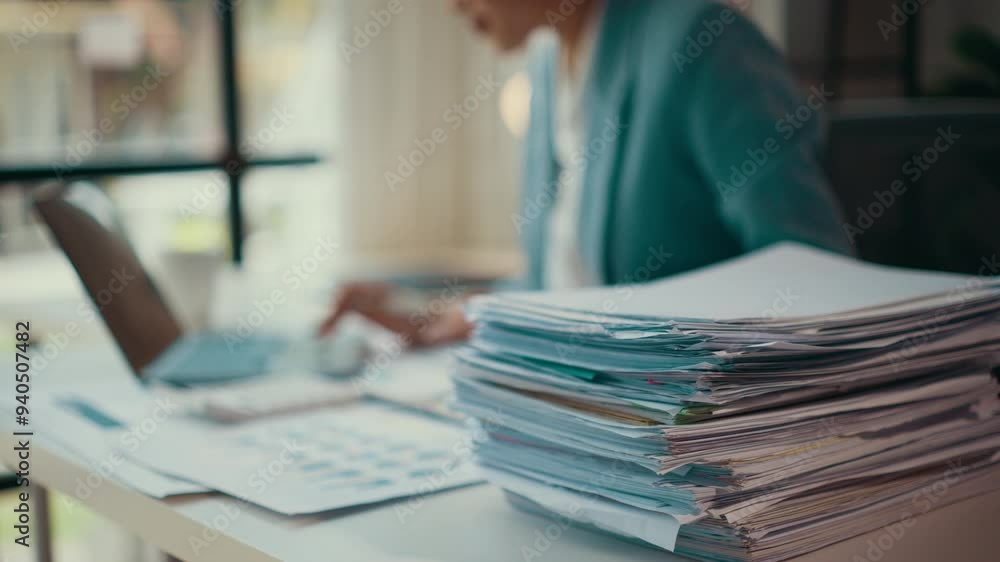 Poster Accountant working diligently at a desk, surrounded by a large stack of invoices. Papers and documents clutter the workspace, reflecting a busy and demanding financial environment