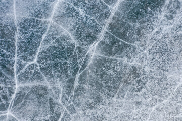 Aerial shot of grid-like patterns on dark blue frozen lake