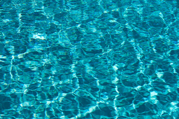 Ripped water in swimming pool. Surface of blue swimming pool, background of water.