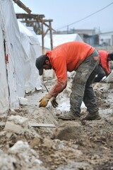 Humanitarian workers constructing temporary shelters for displaced individuals in a disaster-hit area