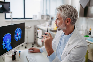Doctor looking at an MRI scan, patient's test results in computer. Recurrence of the disease