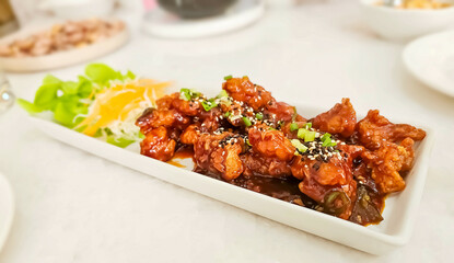 Korean fried chicken crispy crunchy on plate. Yangnyeom chicken is a variety of Korean fried chicken seasoned with a sweet and spicy sauce of gochujang.