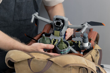 Military engineer takes out army drone with bomb release device from his backpack, concept for...