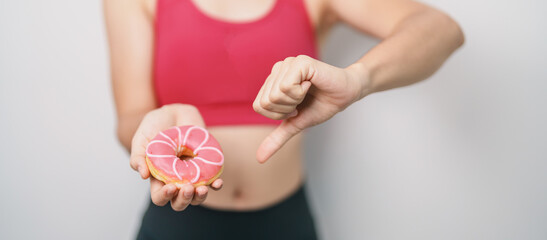 woman hand hold Donut with tape measure, choose stop eating sweet is Unhealthy ealthy food. Dieting...