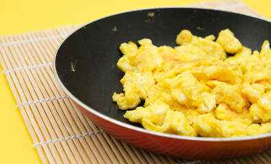 scrambled eggs on frying fan served for breakfast