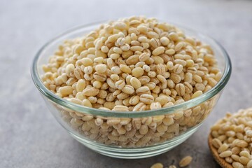 Barley rice in a glass  cup on gray cement background