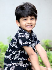 cute little indian boy is dressed up like lord Krishna with Radha name written in Hindi language on...