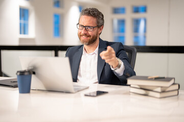 Obraz premium Office worker with laptop at office. Ofice employee remote working in modern office. Businessman on remote meeting, working online in offices place. Business man using computer in office.