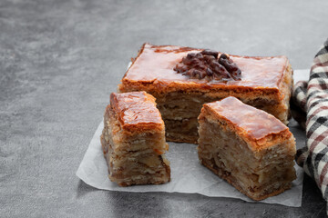 Homemade walnuts and honey baklava on gray background