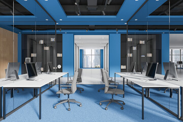 Office workspace interior with pc monitors and desks, panoramic window