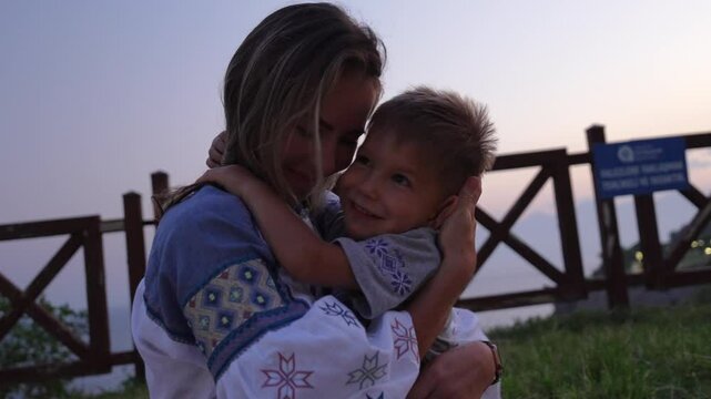 A mother hugs and kisses her son.