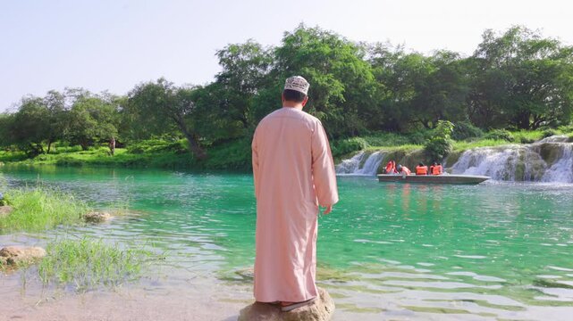 Omani man standing at Wadi Darbat Boating, salalah (Dhofar)