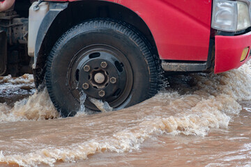 Car driving on a flooded road during a flood caused by heavy rain.