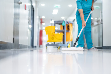A cleaner, dressed in uniform, meticulously mops the hospital's epoxy floor, leaving the patient...