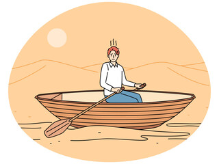 Stressed man rowing in desert