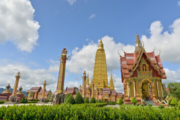 Wat Mahathat Wachiramongkhon or Wat Bang Thong, Krabi Province, Thailand. Beautiful scenery with exterior architecture in the garden of buddhist temple under cloudy blue sky during summer.