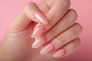 Fototapeta premium Female hand with pink nail design on pink background. Nail polish manicure.