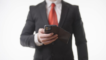 Headless businessman in suit swiping on smartphone