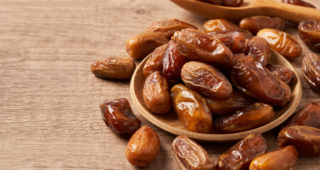 closeup pile of dry date palm fruit in wood bowl food background with copy space